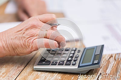 Close up of senior woman counting with calculator Stock Photo