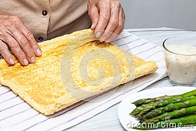 Close up of a senior woman hands stuffing a just baked sponge cake Stock Photo