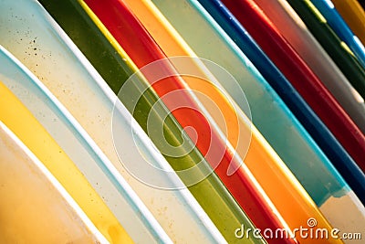 Close up Set of different color surf boards in a stack on sandy beach for rent. Multicolored surfboards as rainbow Stock Photo