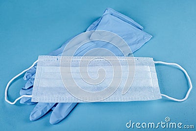 Close-up of set of nurse gloves and a medical mask on a blue background. protection from coronavirus Stock Photo