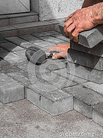 Close up shit of construction worker paving the brick road Stock Photo