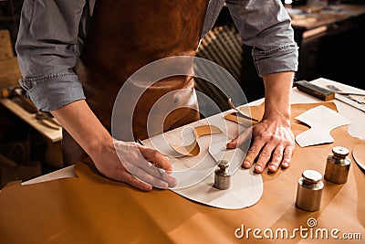 Close up of a shoemaker measuring and cutting leather Stock Photo