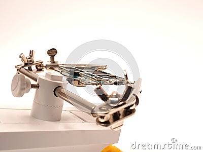 Close up shoot of printed circuit board PCB sitting on a white repair stand with magnifier for better examining small parts Stock Photo