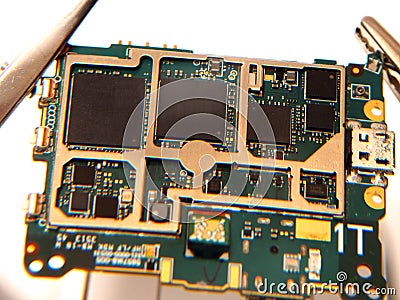 Close up shoot of printed circuit board PCB sitting on a white repair stand with magnifier for better examining small parts Stock Photo