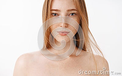 Close-up shot of attractive feminine naked redhead woman with freckles posing over gray background sensualy with Stock Photo