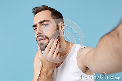 Close up shot bearded young man 20s years old in white shirt doing selfie isolated on blue pastel wall background Stock Photo