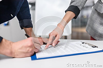 close-up shot of businessman signing contract while manageress pointing Stock Photo