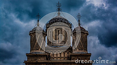 Close-up shot of The Cathedral of Curtea de Arges towers built by Manole in Romania,and black clouds Stock Photo
