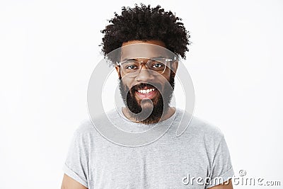 Close-up shot of charming pleasant and delighted dark-skinned bearded male customer in glasses with afro hairstyle in Stock Photo