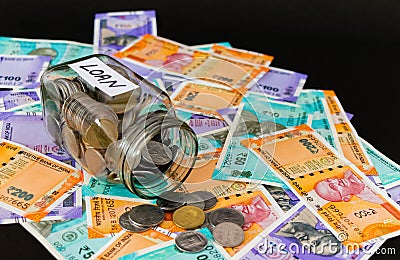 Close up shot of coin filled glass jar with money notes for bank loan concept Stock Photo