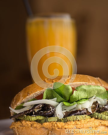 Tasty vegan burger with orange juice in the background Stock Photo