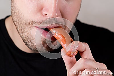 Shot of eating a sausage by an unshaven man Stock Photo