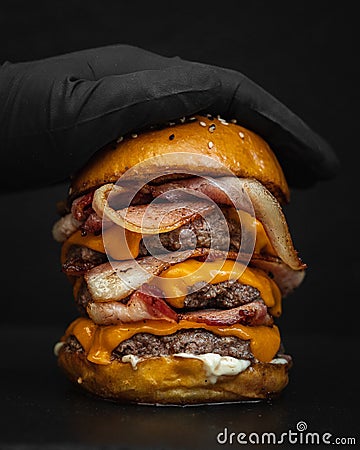 Close-up shot of a giant delicious mouthwatering burger with fried bacon, melted cheese, and beef Stock Photo