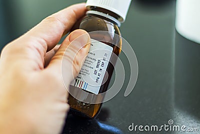 Close up shot of a hand holding a bottle with medicine with expired date. Healthcare Stock Photo