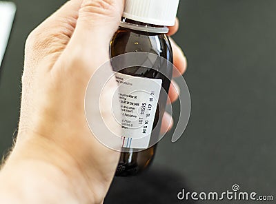 Close up shot of a hand holding a bottle with medicine with expired date. Medicine Stock Photo