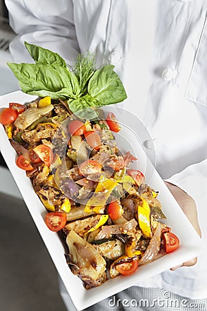 Close-up of hands holding salad in serving dish Stock Photo