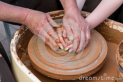 Close up shot of hands making clay bowl during pottery lessons Stock Photo