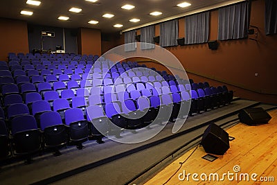 Close up shot of interior of cinema auditorium with lines of blue chairs. Horizontal shot Stock Photo
