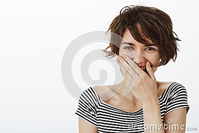 Close-up shot of joyful good-looking optimistic woman with short stylish haircut, laughing out loud or chuckling Stock Photo