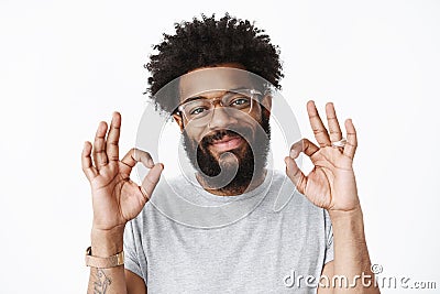 Close-up shot of kind and friendly adult african american bearded guy with pierced nose and afro hairstyle smiling Stock Photo
