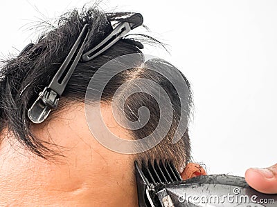 Close up shot of man getting trendy haircut. Male hairstylist serving client, making haircut using machine and comb. the concept Stock Photo