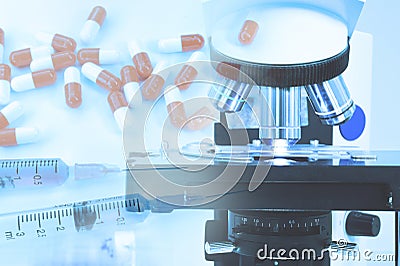 Close up shot of microscope at the blood laboratory and capsules pill Stock Photo