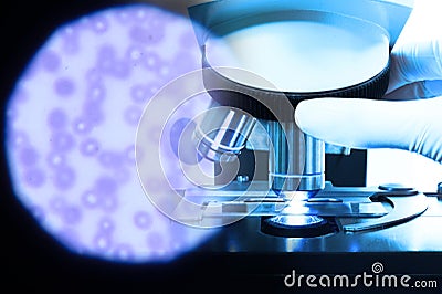 Close up shot of microscope at the blood laboratory and red blood cells under microscope Stock Photo