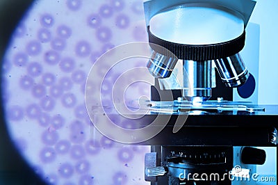 Close up shot of microscope at the blood laboratory and red blood cells under microscope Stock Photo