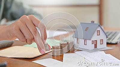 Close - up shot of Model house and hand are arranged coins, House buying concepts Stock Photo