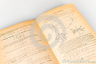 Close up shot of an open old science book containing equations and graphs from different fields: math, physics, chemistry. The Stock Photo