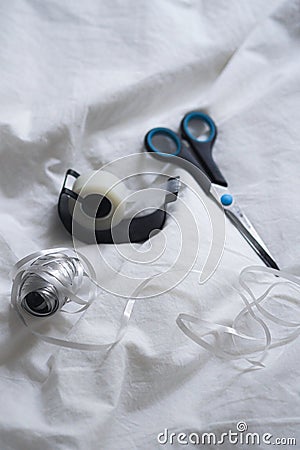 Close-up shot of a pair of scissors sitting next to a roll of adhesive tape Stock Photo