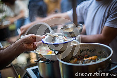 Person serving a portion of fish soup Stock Photo