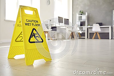 Sign warning about wet floor placed in the office by a commercial cleaning service Stock Photo