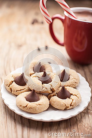 Close up shot of plate of peanut blossom chocolate cookies and hot chocolate on weathered brown wood Stock Photo
