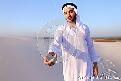 Close-up shot of portrait and hands of young Arab guy in sandy d Stock Photo