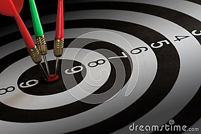Close up shot red and green dart arrows on center of dartboard, metaphor to target success and winner concept Stock Photo