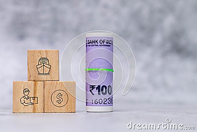 Close up shot of rolled money with wooden cube icons on defocused background- Delivering concept Stock Photo