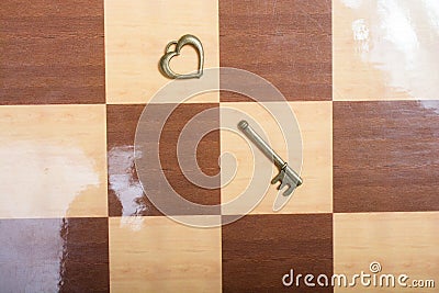 Close up shot of a romantic heart shaped vintage broken key on a chess pattern floor Stock Photo