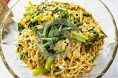 Close-up shot of the Thai homemade cuisine with fried noodles with eggs and vegetables. Stock Photo