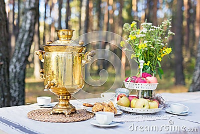 Close-up shot of a traditional russian samovar with cups on a table with snacks Stock Photo