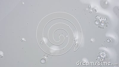 Close up shot of transparent substance on the white background. Cosmetic product gel or serum with bubbles flowing on Stock Photo