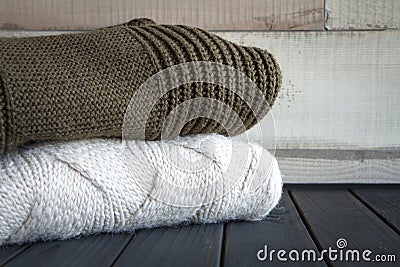 Close-up shot of two knitted from natural wool sweaters, on a black wooden table, selective focus Stock Photo