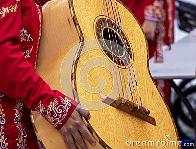 Close up shot of unrecognizable mariachi woman, holds a mariachi GuitarrÃ³n Mexicano (big Stock Photo