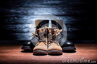 close-up shot of vintage father and son leather boots on wooden surface, Happy fathers Stock Photo