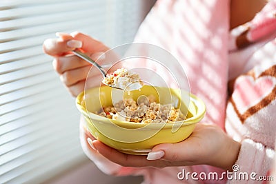 A close up shot of a woman holding a bowl of cereal Stock Photo