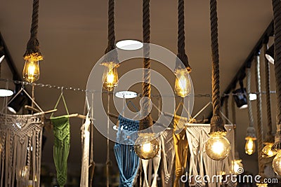 Close-up shot of yellow colored lamp made with rope. Photo was taken in front of the store. There are hammocks for sale in the Stock Photo