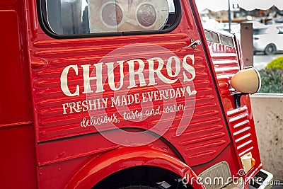 Close up of side front door of red Churros food van at Ashford Outlet Centre in April 2022. Editorial Stock Photo