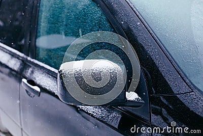 Close-up of side mirror of snow covered blue car Stock Photo