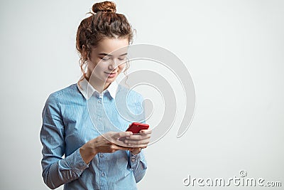 Close up side view shot of smiling nice female teenager with red cellphone Stock Photo