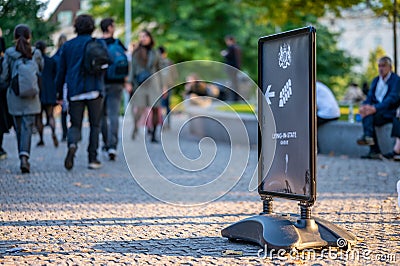 Close up of a sign in Jubilee Gardens for the Queen's Lying in State with a queue of people behind Editorial Stock Photo